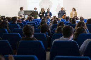 Foto dei musicisti della lezione Livemotiv davanti a un pubblico di studenti