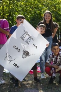 Foto di un bambino che mostra dei rebus disegnati su un cartellone