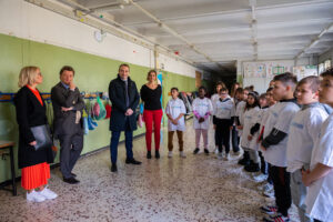 Foto di Andrea Gavosto (direttore Fondazione Agnelli) che stringe la mano a un bambino.