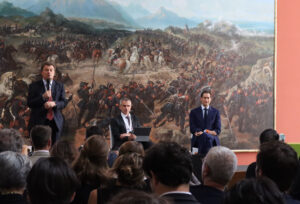 Foto di Andrea Gavosto, Fabiano Schivardi e John Elkann davanti alla platea.