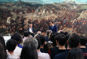 Foto di Fabiano Schivardi e John Elkann che dialogano davanti a una platea di studenti.