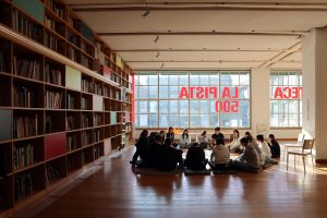 Foto di ragazzi e ragazze in Pinacoteca Agnelli, seduti in cerchio.